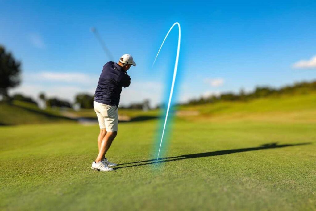 A golfer in a white hat and blue shirt showing how to hit a draw in golf