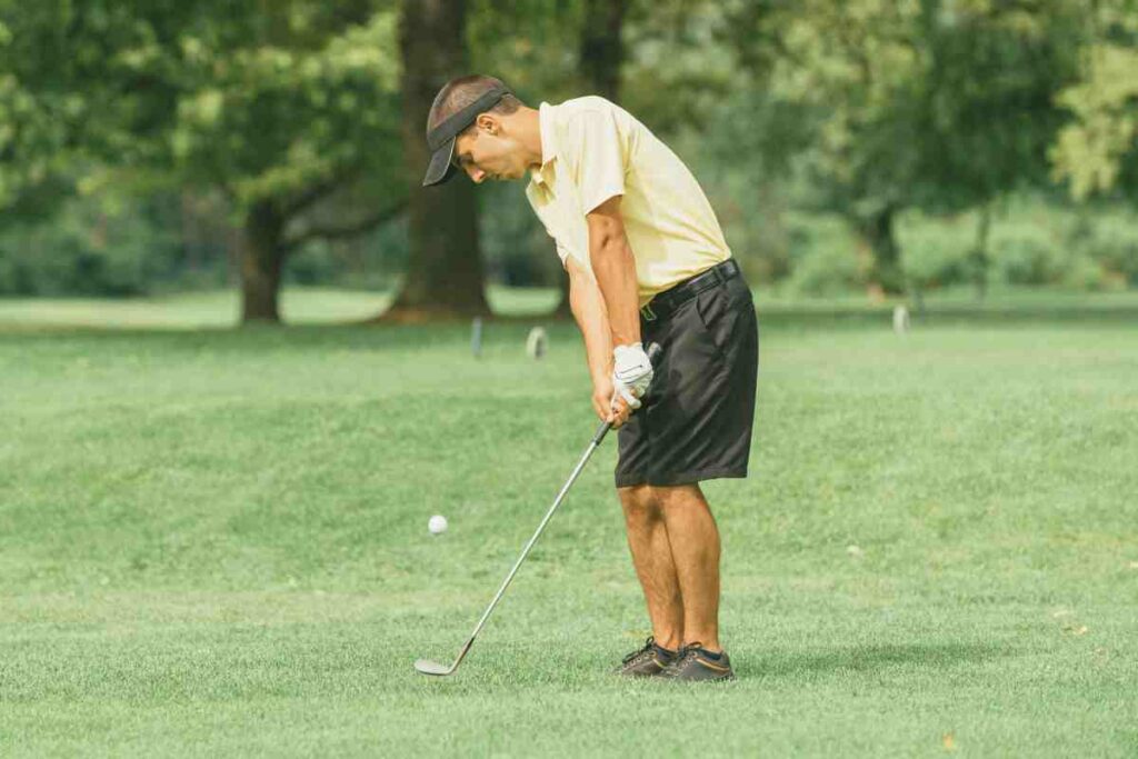 man in yellow shirt in a chip shot golf stance