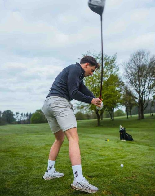 A male hitting a golf ball off the tee with a driver