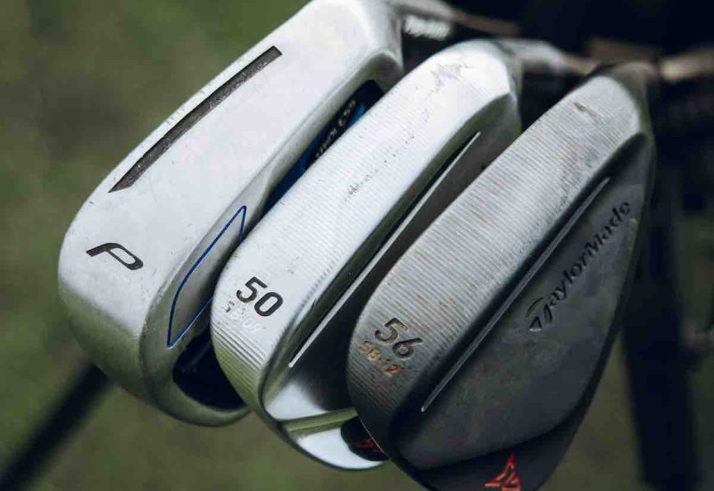 A pitching wedge, gap wedge and sand wedge in a golf bag. All have varying degrees of loft.